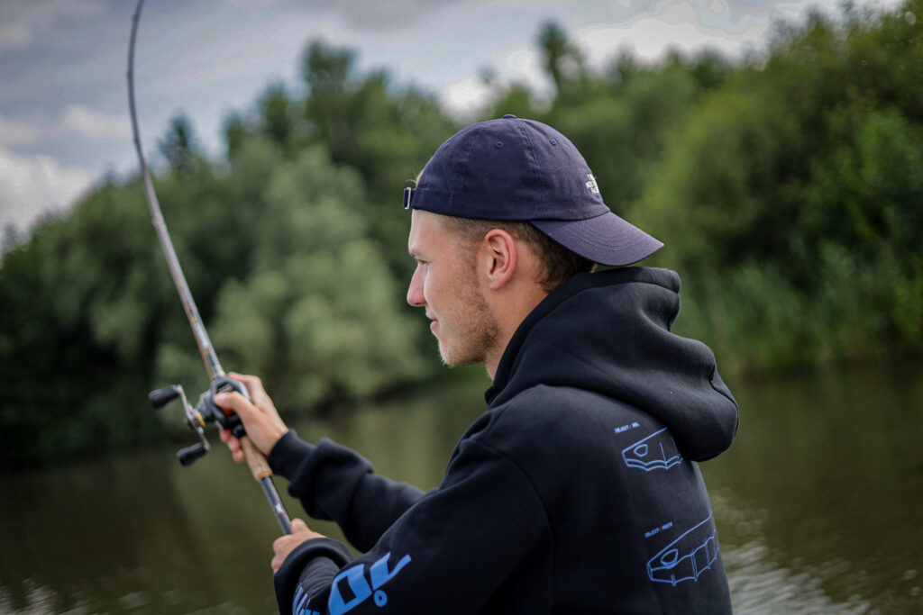 Ein Angler wirft seine Baitcast Rute aus.