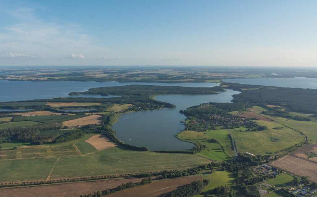 Eine Luftaufnahme der Mecklenburger Seenplatte an einem sonnigen Tag.