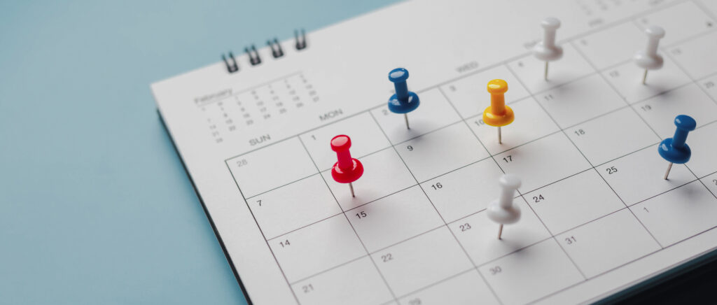 Stecknadeln stecken in einem Terminkalender