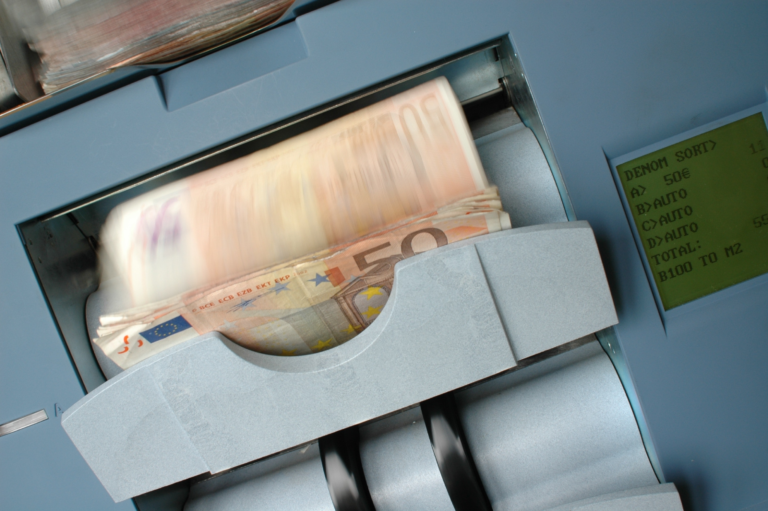 Ein grauer Rechnungszähler zählt viele 50-Euro-Banknoten.
