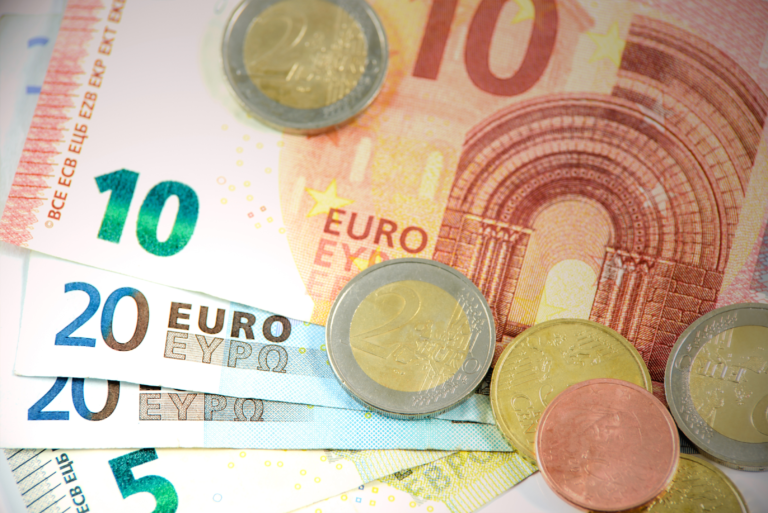 Eine Nahaufnahme von Euro-Banknoten und -Münzen.