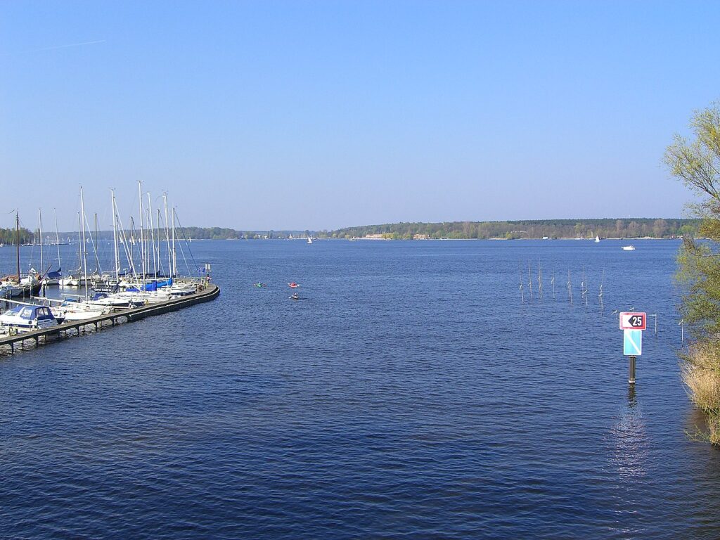 Ein See mit einem Bootssteg an einem sonnigen Tag.