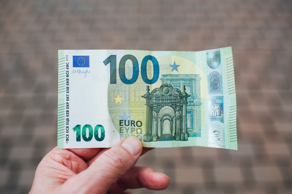 Eine Hand, die eine 100-Euro-Banknote hält.
