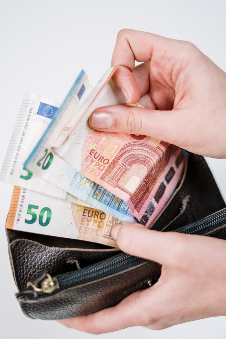 2 Hände halten einen Brieftasche und mehrere Euroscheine.